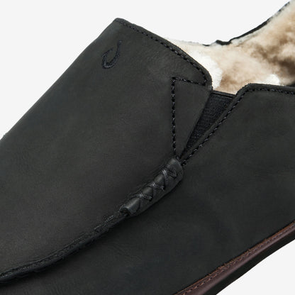 Black leather slipper with fleece lining, showing elastic gusset and stitched detailing on the upper.