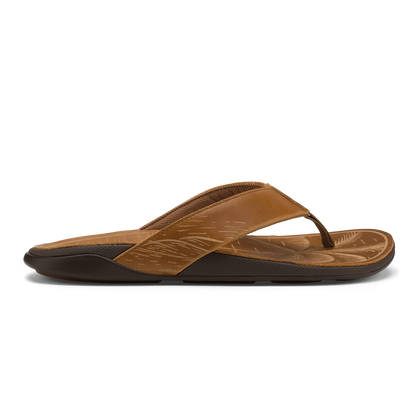 Tan leather flip-flop with black sole and embossed leaf pattern on footbed.
