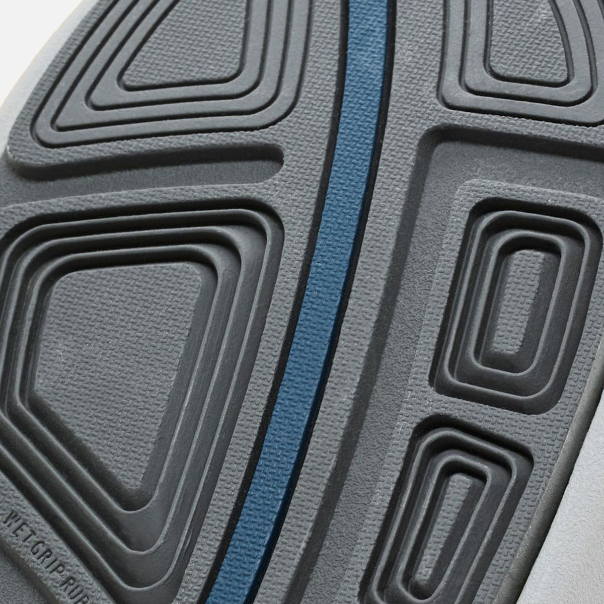 Close-up of shoe sole featuring gray and black concentric pattern with blue coral stripe down the center.