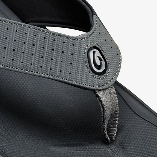 Gray perforated sandal with black sole and adjustable heel strap with metal accent.