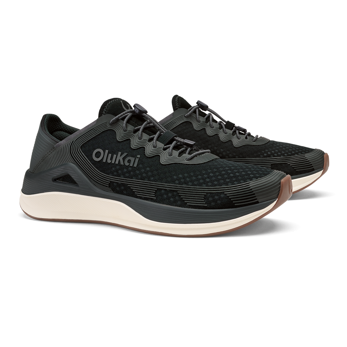 Black OluKai ʻAhi running shoe with cream-colored sole and charcoal grey accents, shown from the side.