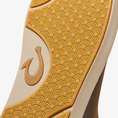Shoe sole with tan leather panel and gold textured rubber base featuring curved wave pattern design.