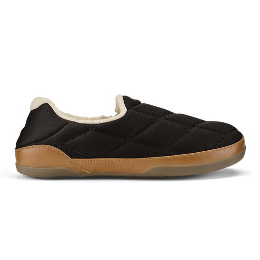 Black quilted slip-on slipper with tan leather trim and cream fleece lining.