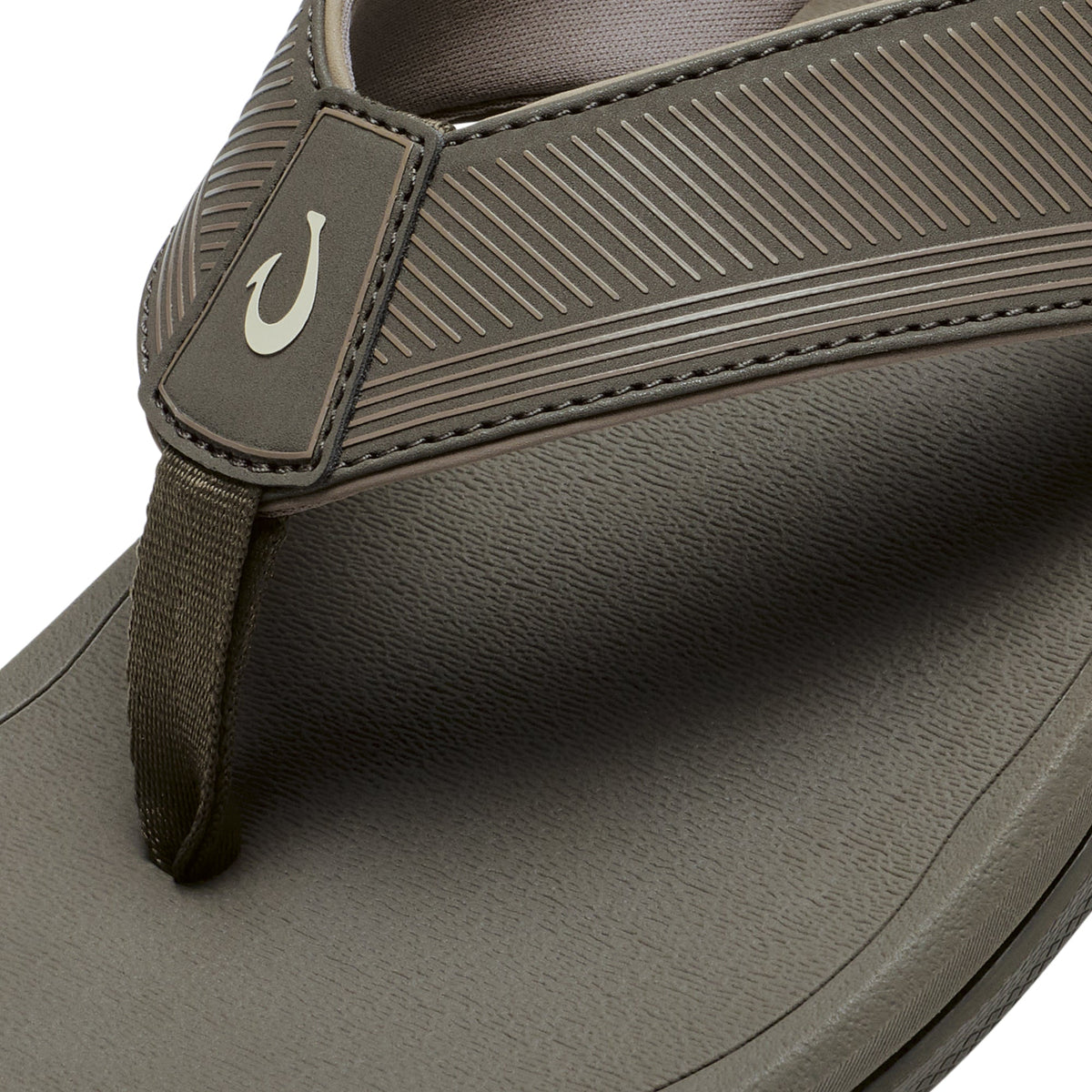 Brown sandal with textured upper strap, fabric toe post, and grooved sole with white hook logo detail.