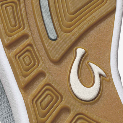 Tan and white slip-on shoe sole with curved geometric patterns and a cream-colored logo detail.