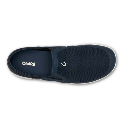 Trench blue slip-on shoe with textured mesh upper, white sole, and OluKai branding, shown from above.