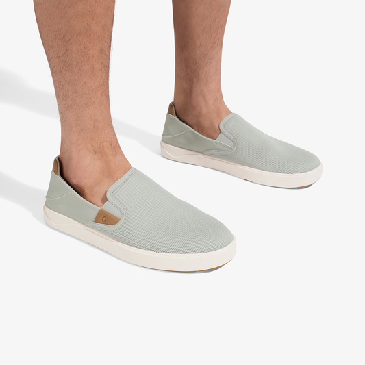 Light grey slip-on sneakers with tan accents and cream sole, worn on feet.