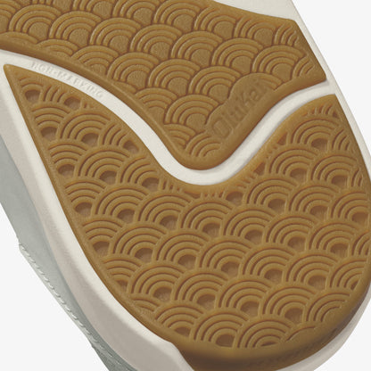Tan and white shoe sole with geometric arc pattern detail and embossed branding.