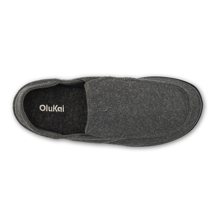 Dark gray knit slipper with black fleece lining, shown from above with OluKai branding visible inside.