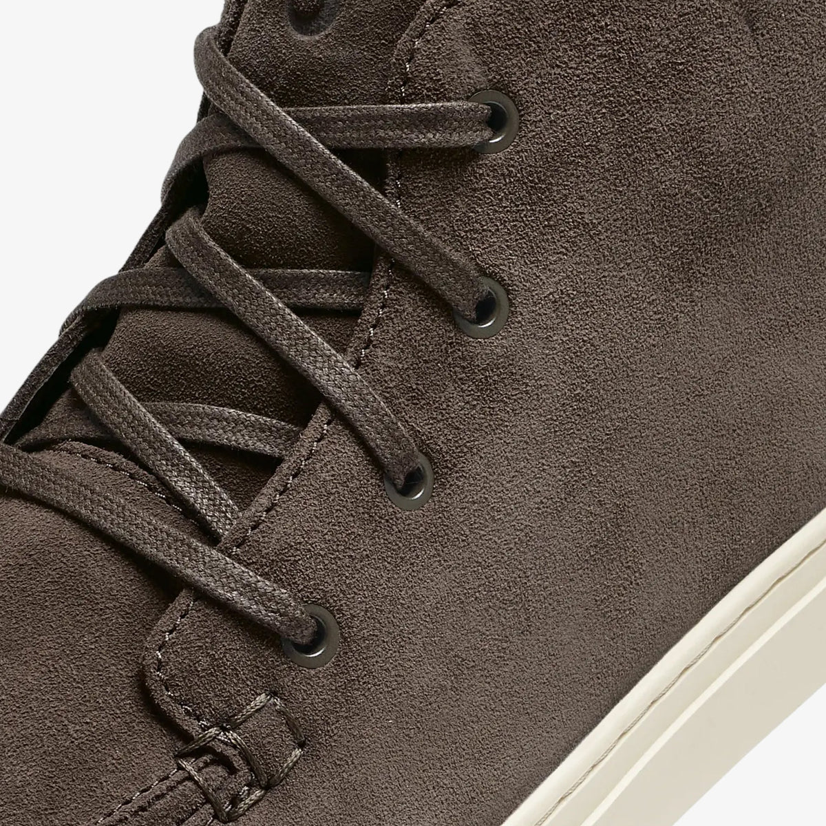 Dark gray suede chukka boot with black laces and cream-colored sole, shown from side detail.