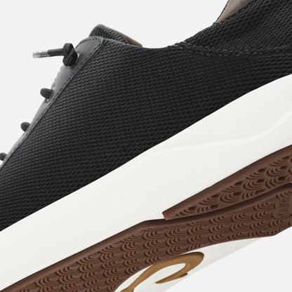 Black mesh sneaker with white midsole, brown textured outsole, and lace-up closure detail.