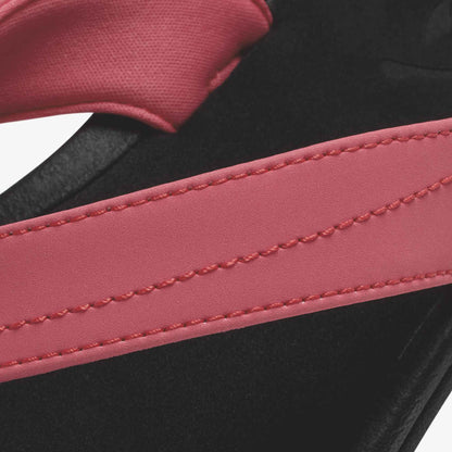 Hot pink strap with stitching detail over black textured material.