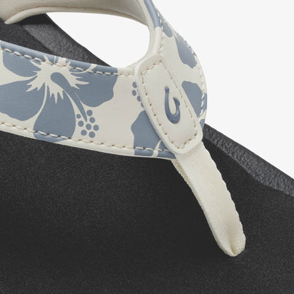 White and slate blue floral patterned strap with cream handle on black fabric bag.