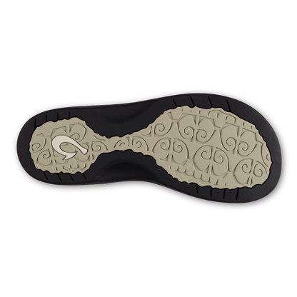 Shoe sole with ecru patterned footbed and black rubber outsole with tread.
