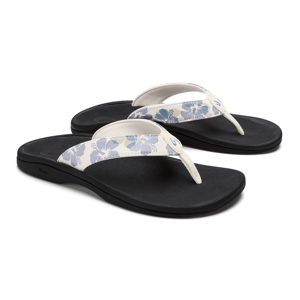 Pair of black flip-flops with white straps featuring blue floral pattern.
