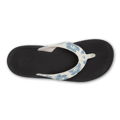 White and blue floral flip-flop with black sole, viewed from above.