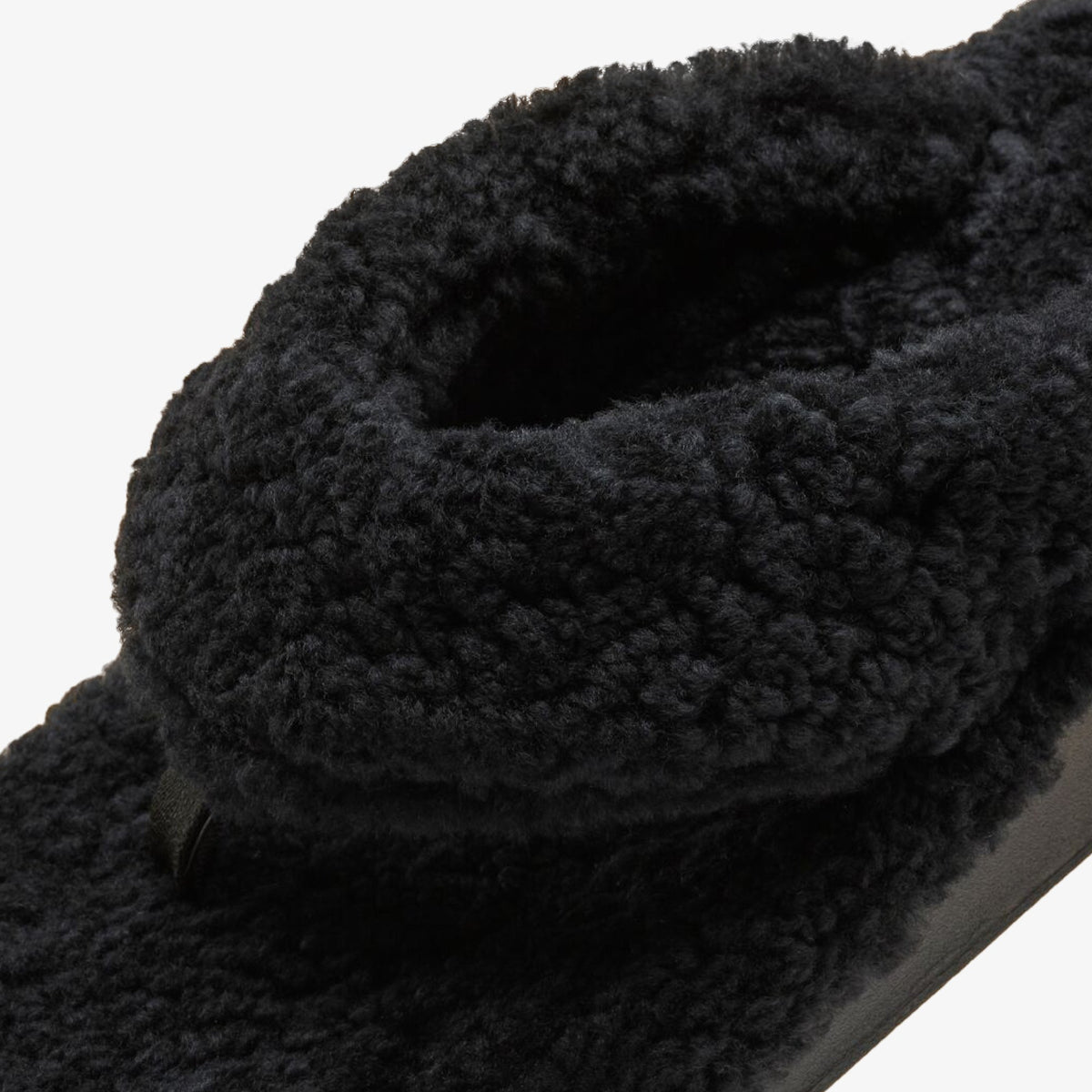 Black textured knit scarf with chunky cable knit pattern and gathered folds.