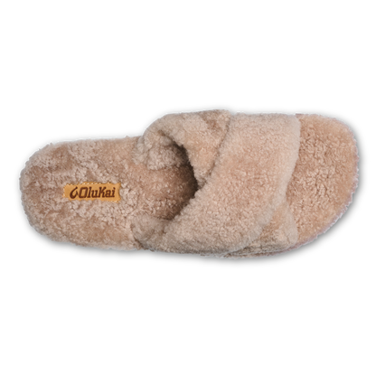 Tan fluffy slipper with cushioned sole and brand label on insole, viewed from above.