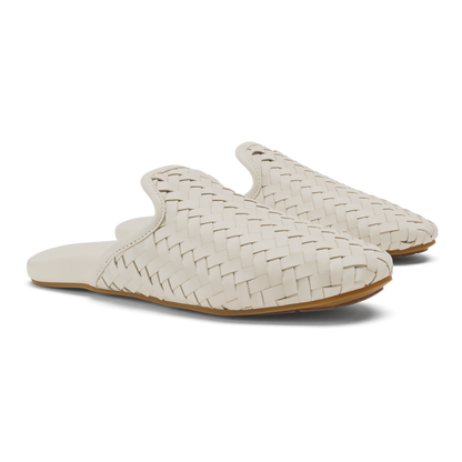 Pair of cream woven slip-on mules with tan sole and rounded toe.