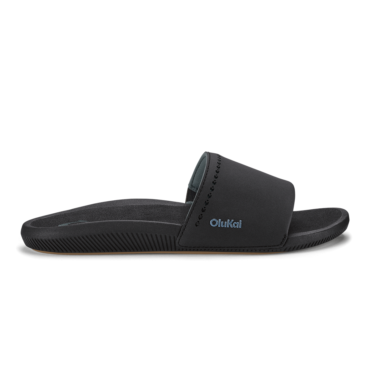 Black slide sandal with padded upper and textured sole featuring OluKai branding.