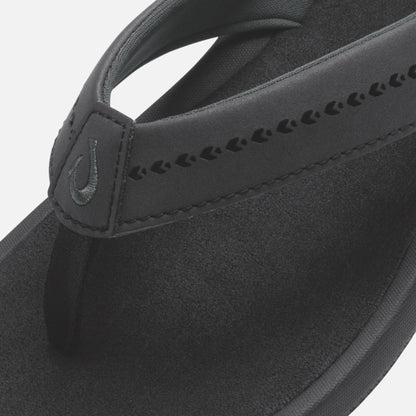 Black slide sandal with textured strap featuring decorative cutout details and padded footbed.