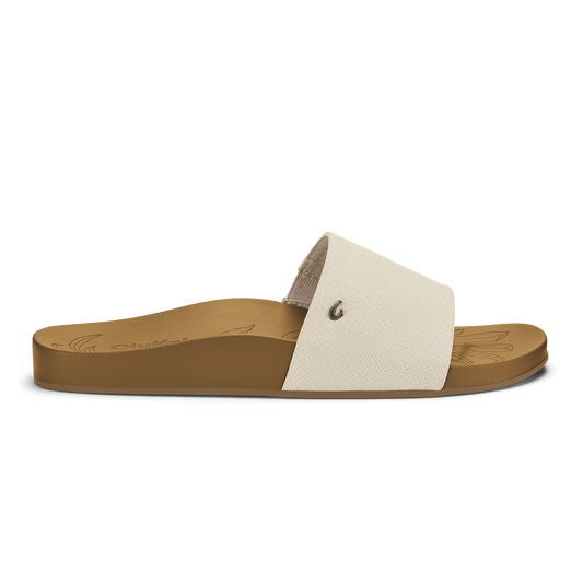 Tan slide sandal with cream textured upper strap and small metal rivet detail.