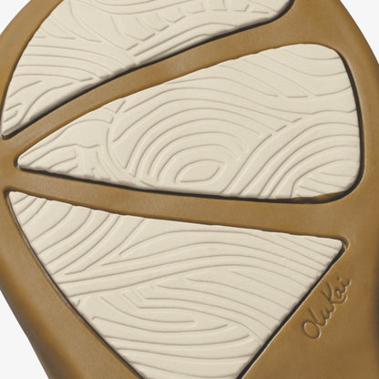 Tan and cream decorative object with three curved sections featuring linear wave patterns and embossed branding.