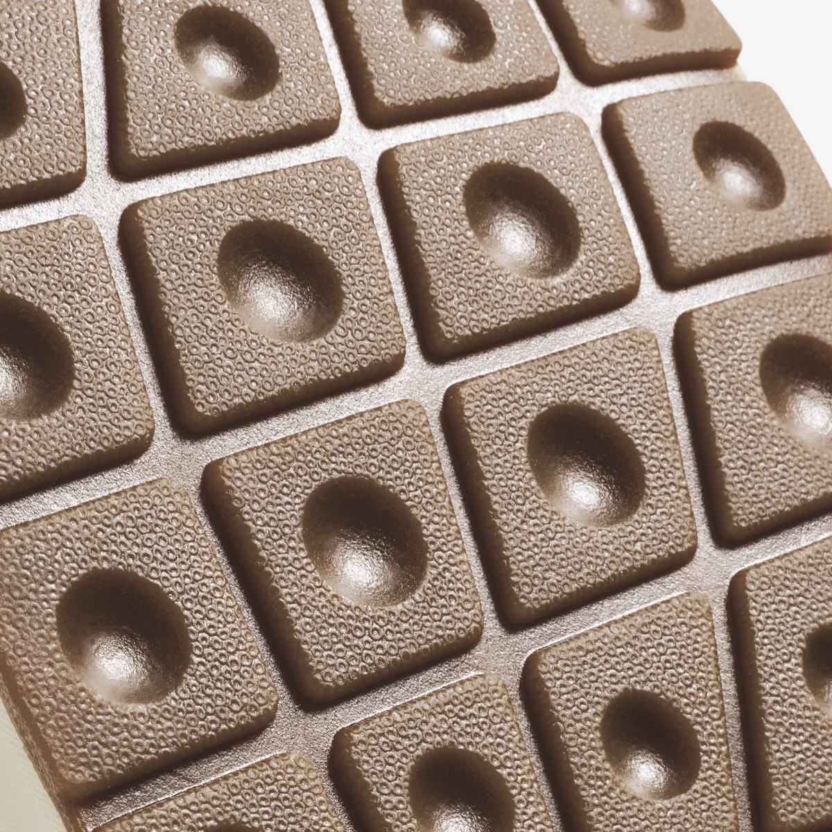 Beige textured tiles with circular recessed centers arranged in a grid pattern.