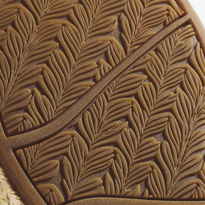 Tan leather with embossed feather or leaf pattern detail and curved edge stitching.