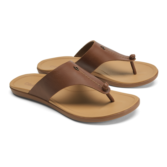 Pair of brown leather thong sandals with tan soles and decorative button details on the straps.