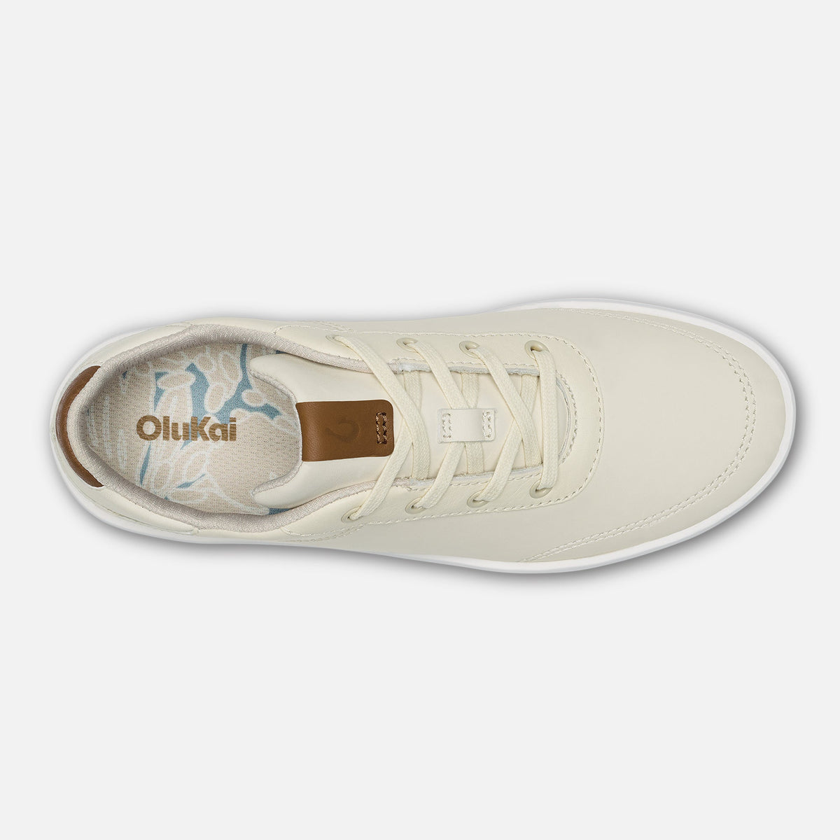 White canvas sneaker with tan heel tab and white laces, viewed from above.