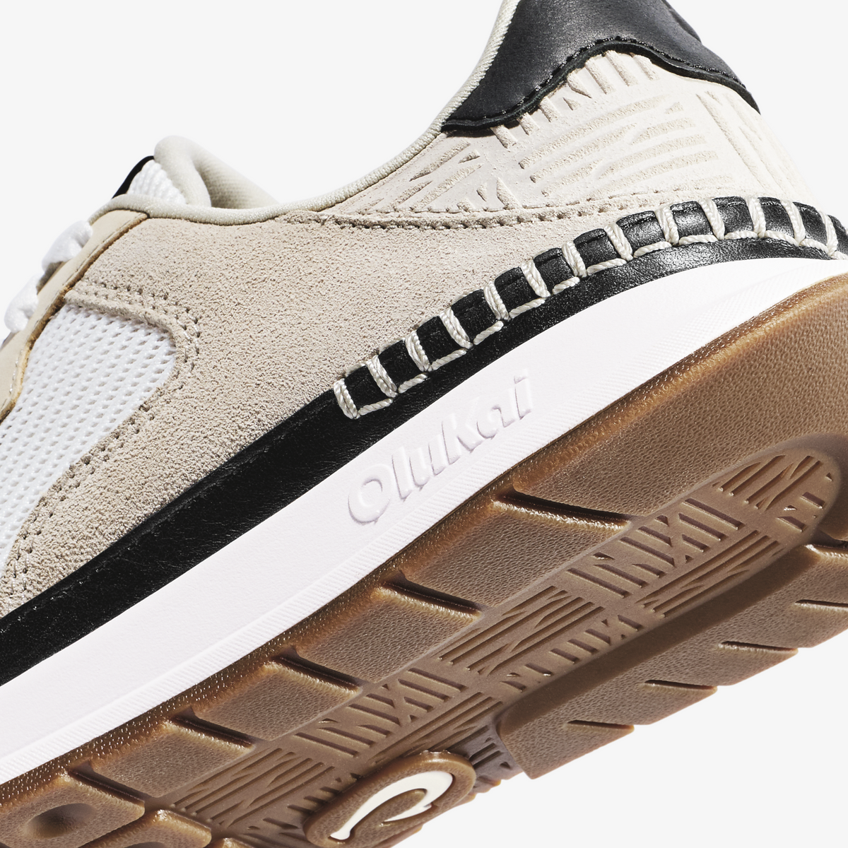 Koke sneaker in bright white and ecru with black heel tab, black and white striped side panel, and tan rubber sole.