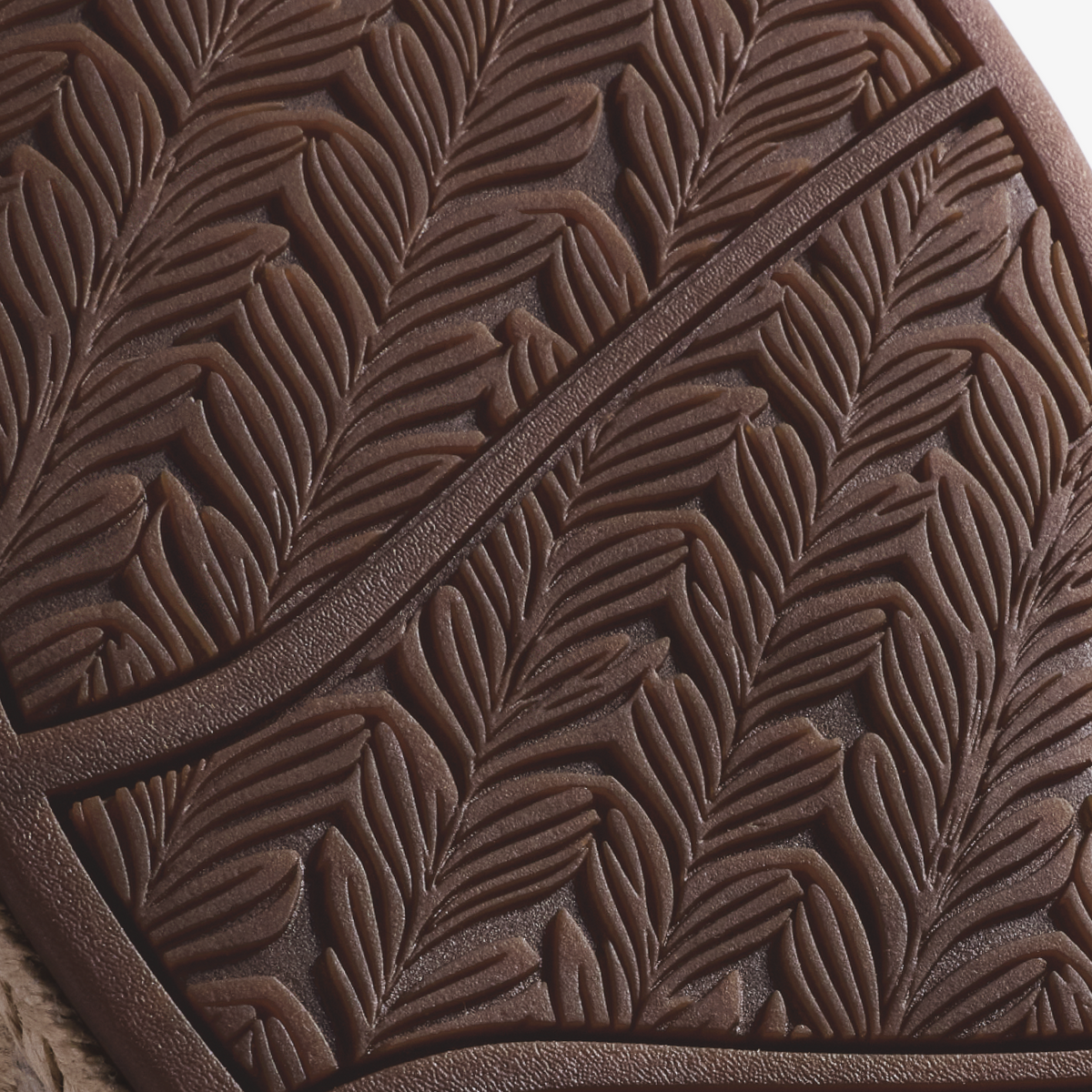 Warm sand-colored leather with embossed leaf pattern and diagonal stitched detail.