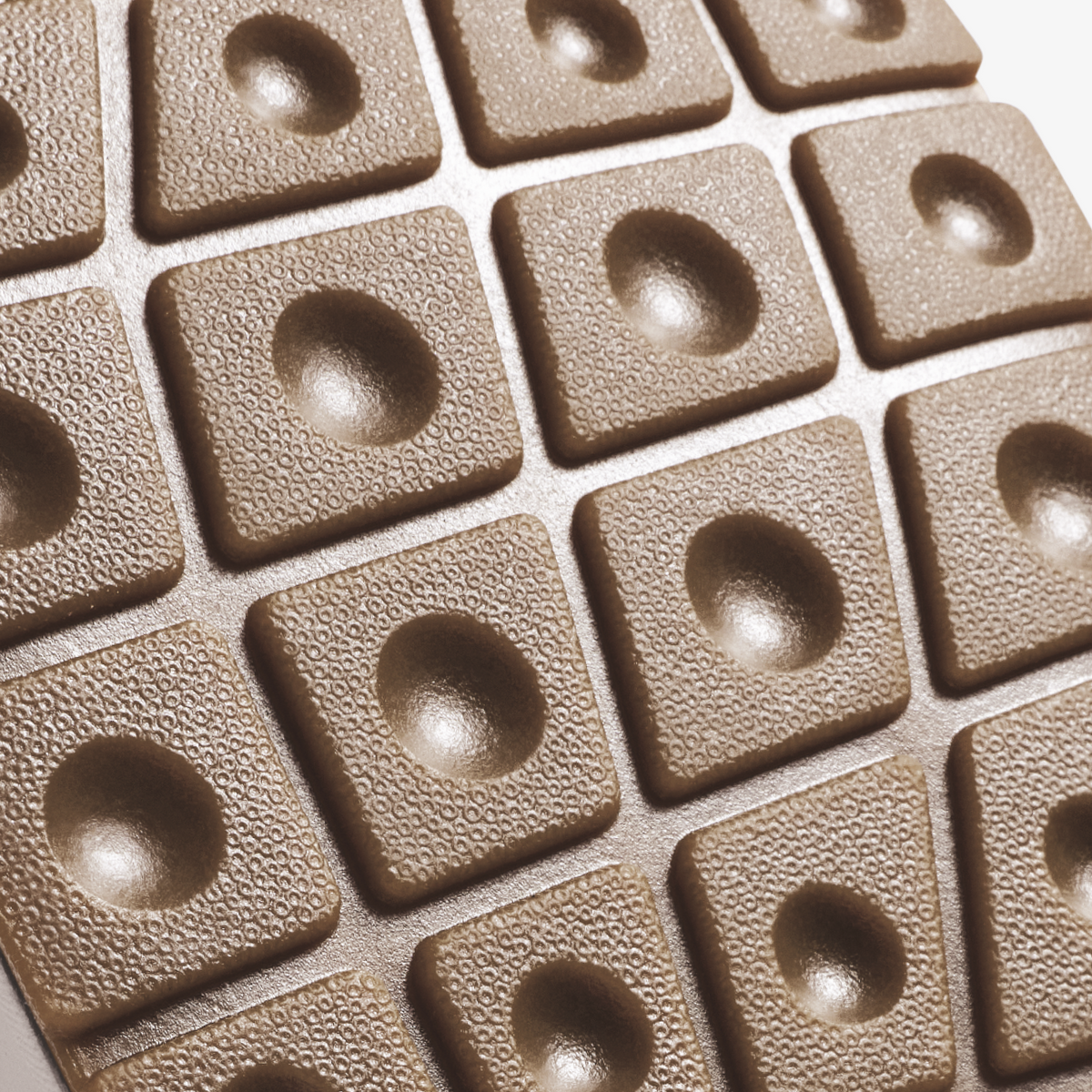 Beige textured tiles with hemispherical indentations arranged in a grid pattern.