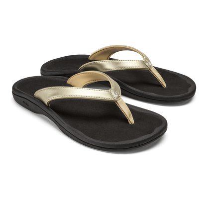Pair of black flip-flops with gold and metallic straps and cushioned soles.