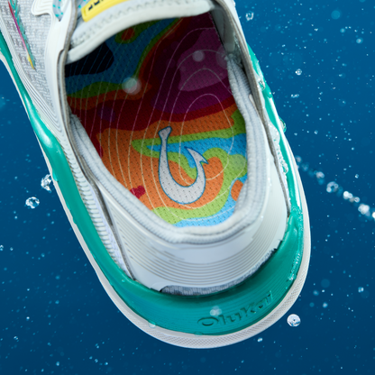 White and turquoise sneaker with colorful rainbow insole featuring a hook design, shown from above.